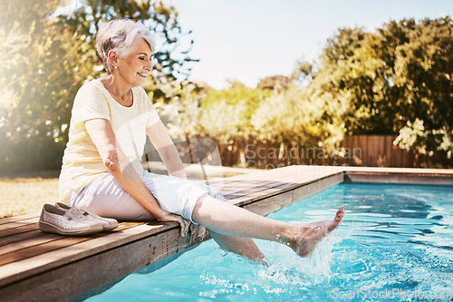 Image of Relax, travel and senior woman by the pool while on a vacation, adventure or outdoor trip in summer. Happy, smile and elderly lady in retirement with her feet in the swimming pool at a holiday resort