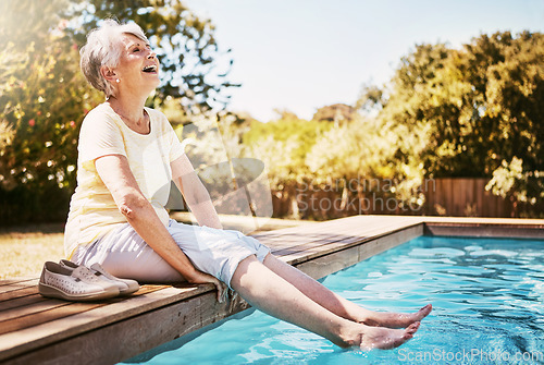 Image of Elderly woman with her feet in the water of the pool while on a vacation, adventure or outdoor trip in summer. Happy, smile and senior lady in retirement relaxing by swimming pool at a holiday resort