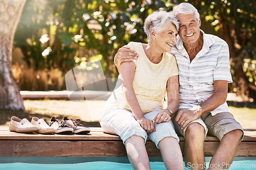 Image of Senior couple, hug and swimming pool for summer vacation, love or relax spending quality bonding time together. Happy elderly man holding woman relaxing with feet in water by the poolside outside