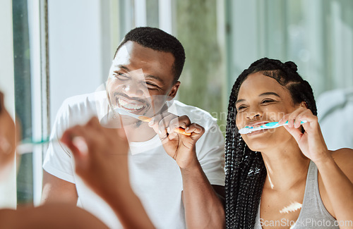 Image of Brushing teeth, dental and oral hygiene with a black couple grooming together in the bathroom of their home. Health, tooth care and cleaning with a man and woman bonding during their morning routine