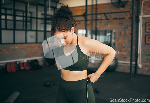 Image of Fitness, exercise and woman at gym to check body progess after training for health, balance and wellness. A young sports female or athlete strong and healthy while on diet and active to lose weight