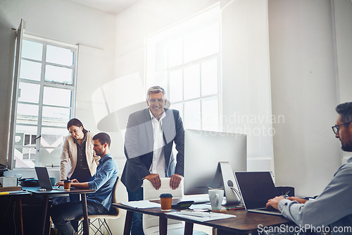 Image of Leadership, teamwork and portrait of business man in office workplace. Coworking, ceo and senior male employee working on marketing report, advertising or sales project with colleagues in company.