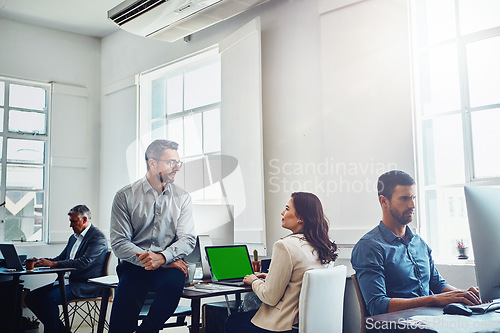 Image of Teamwork, laptop green screen and business people in office talking, discussion or conversation. Collaboration, mock up and employees, man and woman planning marketing, advertising or sales project