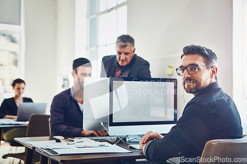 Image of Office, portrait and business man by computer in company workplace. Planning, coworking or mature male employee on pc working on marketing report, advertising proposal or sales project with coworkers