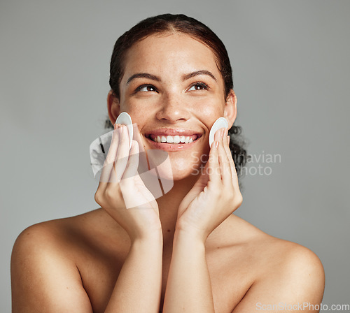 Image of Skincare, beauty and woman with cotton pad for face glow, cleaning and dermatology on a grey studio background. Spa, cosmetology and model with product for facial clean, body health and acne