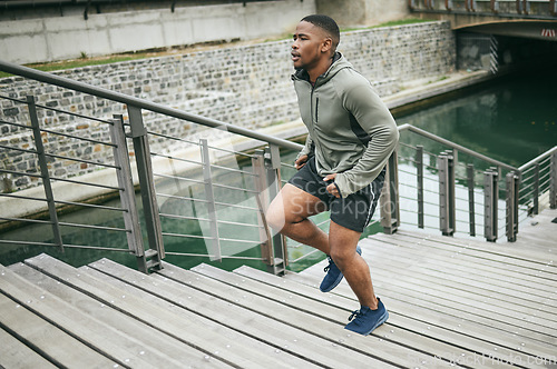 Image of Fitness, runner or black man running on stairs for legs training, exercise or workout in city of in Miami, Florida. Steps, bridge or healthy sports athlete with wellness goals, motivation or mission