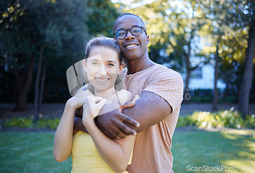 Image of Couple in portrait, date in park with hug and outdoor in nature, love and commitment with interracial relationship. Trust, support and happy people, black man and woman smile on face with fresh air