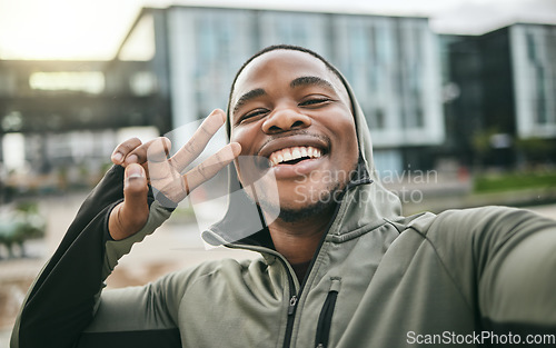 Image of Fitness, selfie and man with peace sign in the city while doing a cardio exercise in Nigeria. Happy, smile and Nigerian guy taking picture while running for sports, race or marathon training in town.