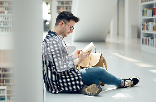 Image of Man, student and reading in library with book for knowledge, education or learning at the university. Male learner in study with books for thesis, project or assignment for scholarship at the campus