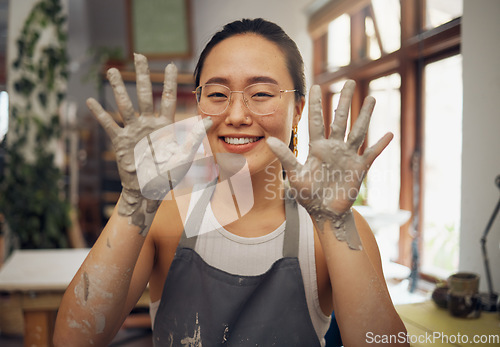 Image of Pottery, happy and hands of a portrait woman at a messy workshop for art, design and work. Small business, dirty and creative artist with clay at a studio for creativity and artistic entrepreneurship