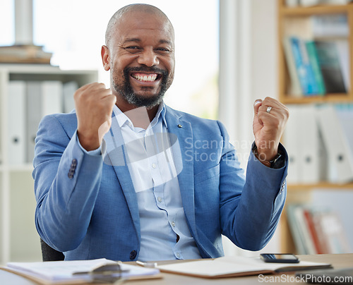 Image of Success, winner and businessman at his desk in office for company profit, stock market or financial increase, promotion or bonus. Happy news, fist and winner corporate black man in a career portrait