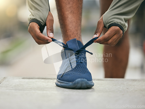 Image of Fitness, health and black man tie running shoes before an outdoor cardio exercise in the park. Sports, runner and African male athlete preparing for endurance training for race, challenge or marathon