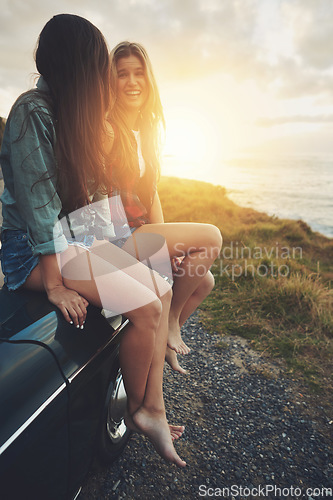 Image of Women friends, road trip and sunset in nature for travel, adventure and freedom while happy outdoor. Funny girls on a car while talking on vacation drive or journey with transport and ocean view