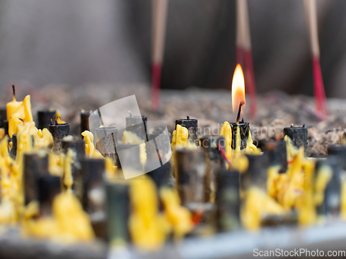 Image of Single candle burning at Buddhist temple in Thailand