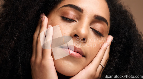 Image of Beauty, face and skincare with a model black woman touching her skin in studio on a brown background. Peace, wellness and relax with an attractive young female posing with her hands on her cheeks