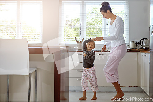 Image of Kitchen dance, mom and girl in the morning at home with happiness dancing together. Mom, child and mama care holding hands with a young kid in a house happy about funny family with a smile