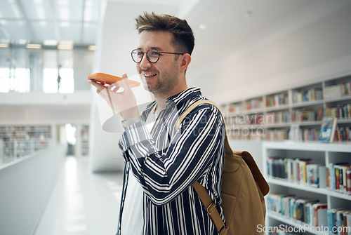 Image of Man, phone call and speaker in library, smile and connection for communication, talking and planning study date. Young male, student or academic with smartphone, speaking or conversation in bookstore