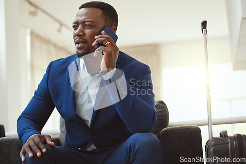 Image of African man in hotel, on business call and listening to voice message in Chicago for work travel. Corporate professional, young black entrepreneur talking on smartphone and luxury airport building
