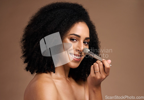 Image of Black woman, studio portrait and brush for foundation, beauty or cosmetic self care by backdrop with smile. Model, happy and powder makeup for face, skincare glow or application by studio background