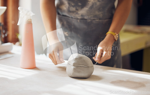 Image of Woman, hands and cut clay in pottery studio, workshop and creative startup for sculpture product. Ceramic artist, wire cutter and process for production, manufacturing and designer in small business