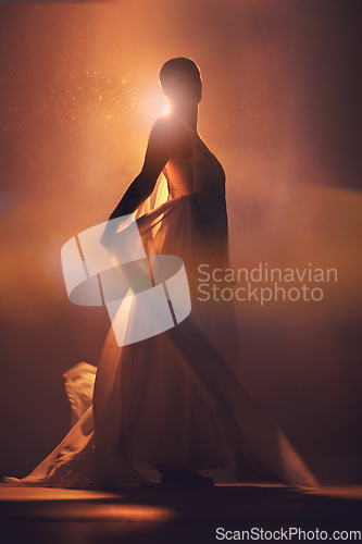 Image of Orange lighting, fantasy and silhouette of woman with stylish dress for creative fashion, art deco and beauty. Dance, aesthetic and shadow of girl pose for dream, magic and freedom in glowing studio