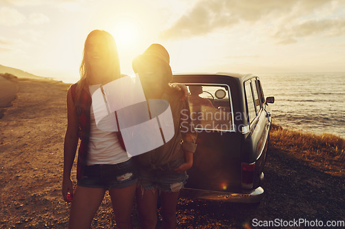 Image of Sunset lens flare with women, car and road trip, travel with friends at beach, outdoor with nature and sea holiday. Transportation, freedom and sunshine on summer vacation, happiness with adventure