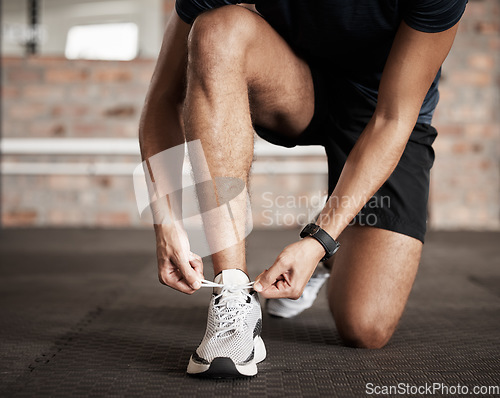 Image of Fitness, man and tying shoe lace getting ready for running exercise, workout or training at gym. Sporty male, person or guy shoes in preparation for sport run, cardio or warm up on floor at gymnasium