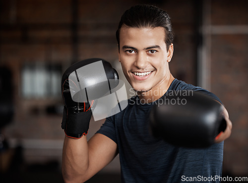 Image of Portrait, fitness and workout with a boxer man training for a fight or competition in a gym for sports. Health, exercise and power with a young male athlete boxing in an mma or self defense club