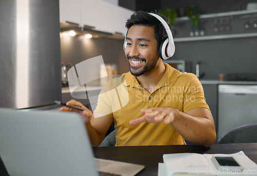 Image of Happy man, headphones and video conference on laptop in home office while online, talking and on webinar. Entrepreneur person at desk working remote with virtual communication for freelance work