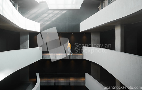 Image of Architecture, lighting and walking woman in a building for work, entrepreneurship and start of job. Design, professional and designer on a walk in the corridor of an elegant and modern workplace