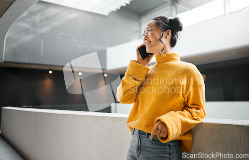 Image of Phone call, communication and mockup with an asian woman talking while standing in a hallway. Mobile, networking and conversation with an attractive young female speaking on her smartphone indoor
