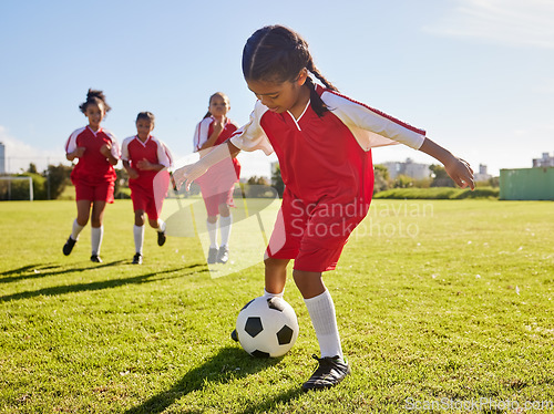 Image of Soccer, training or sports and a girl team playing with a ball together on a field for practice. Fitness, football and grass with kids running or dribblinf on a pitch for competition or exercise