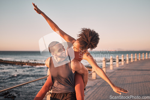 Image of Beach, happy and couple piggyback in summer enjoying holiday, vacation and quality time on weekend. Love, dating and black man and woman relax after running, fitness workout and training by ocean