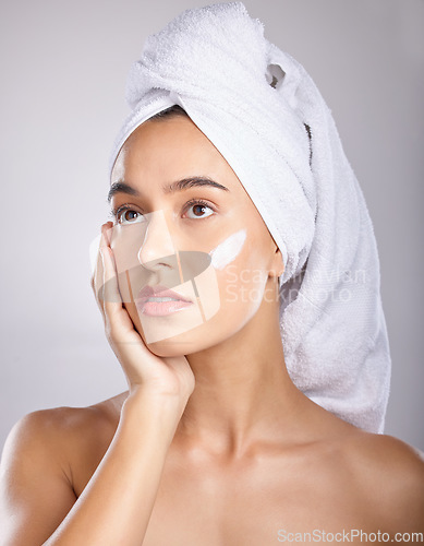 Image of Woman, head towel and cream for cosmetics, makeup and face detox on grey studio background. Young female, lady and organic facial for treatment, clear and healthy skin for natural beauty and skincare