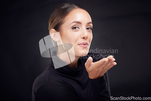 Image of Woman, studio portrait and blow kiss with hand for beauty, makeup and wellness by black background. Model, girl and kissing face with fashion, self care and cosmetics for dark aesthetic by backdrop