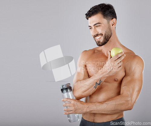 Image of Man, water bottle and apple for healthy lifestyle, diet and wellness in grey studio background. Male, guy and bodybuilder with fruit, hydration and healthcare for fitness, nutrition and motivation