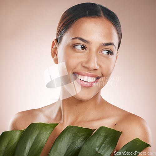 Image of Woman, face skincare and monstera leaf on pink studio background for organic dermatology, self love or healthcare wellness. Happy, smile or beauty model with green plant, natural makeup or cosmetics