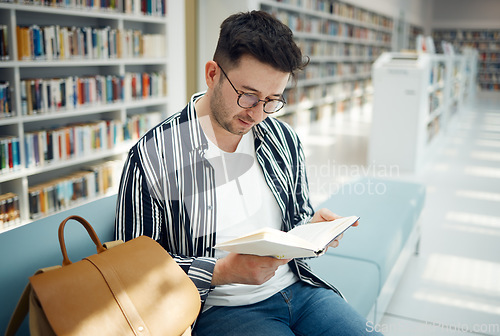 Image of Education, man and student reading in library, knowledge and studying for exams, test and intelligent. Young male, guy and academic with book, learning and university study area, peace and creative