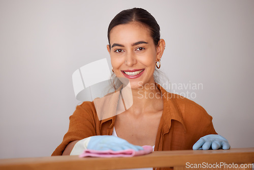 Image of Portrait, cleaning and wipe with a woman housekeeper or cleaner using a rag cloth to dust furniture. Face, bacteria and dirt with a female working to service a dirty apartment for housekeeping