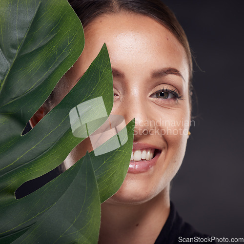 Image of Beauty, skin and face with leaf and woman, skincare with nature aesthetic, natural cosmetics and facial portrait against studio background. Smile, glow with organic cosmetic treatment and wellness.