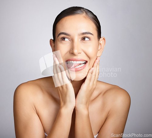 Image of Face, beauty and tongue with a model woman in studio, thinking about skincare on a gray background. Idea, facial and playful with an attractive young female posing to promote natural skin treatment