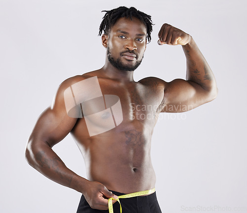 Image of Muscular black man, tape measure and isolated flexing on a grey background for fitness, weight loss or dieting. Portrait of African American male muscle flex, healthy body or empowerment