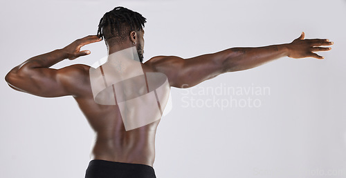 Image of Back, body and mockup with a model black man posing in studio on a gray background for fitness or exercise. Muscle, health and wellness with a strong male athlete standing or flexing for power