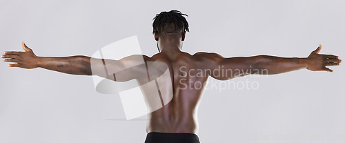 Image of Back, arms and muscular with a model black man posing in studio on a gray background for fitness or exercise. Muscle, health and wellness with a strong male athlete standing or flexing for power