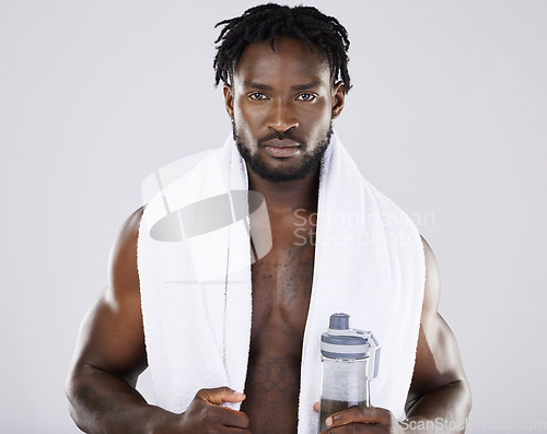 Image of Fitness, portrait and black man with towel and water for sports in studio for strong body muscle. Health and wellness of a sexy male bodybuilder model after exercise, workout and training for power