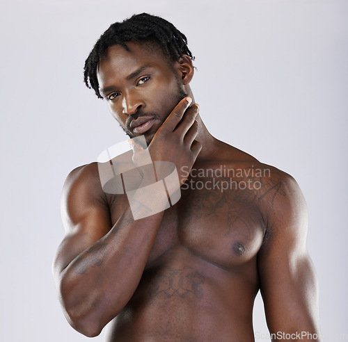 Image of Black man, muscle and standing isolated on a grey background thinking, grooming or profile. Portrait of fit or attractive African American male, person or guy model in thought posing in the studio