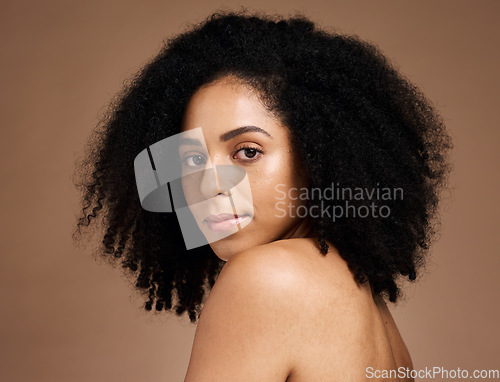 Image of Portrait, beauty and afro with a model black woman in studio on a brown background for natural skincare. Face, cosmetics and hair with an attractive young female posing to promote cosmetics