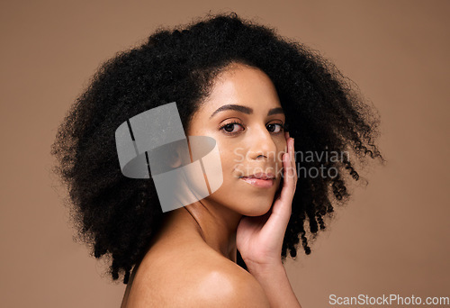 Image of Portrait, beauty and afro with a model black woman in studio on a brown background for natural skincare. Face, cosmetics and hair with an attractive young female posing to promote cosmetics