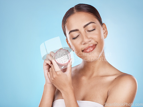 Image of Skincare, nutrition and woman with a dragon fruit for beauty, body health and cosmetic diet on a blue background in studio. Detox food, marketing and model advertising a fruit for healthy skin