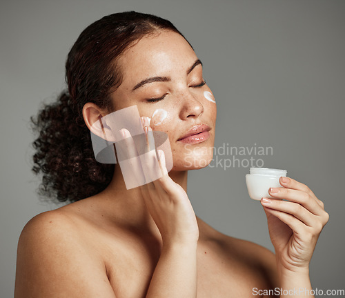 Image of Black woman, face and skincare cream for beauty wellness shine, cosmetics dermatology and salon spa product in studio. African girl hands, facial moisturizer and spf sunscreen or luxury makeup glow